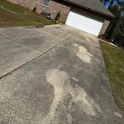 Concrete driveway covered in mildew and stains before pressure washing