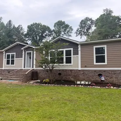 Single-story home with a tidy lawn maintained in the Hattiesburg area